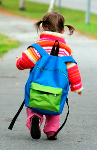 Niña con una mochila muy pesada