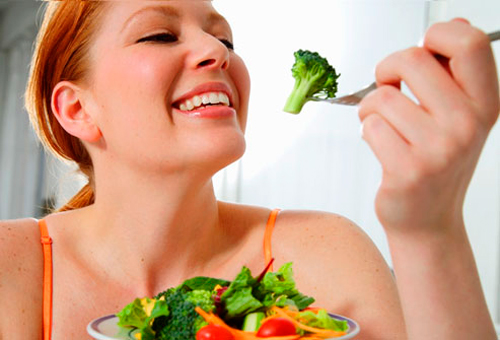 Mujer comiendo brocoli