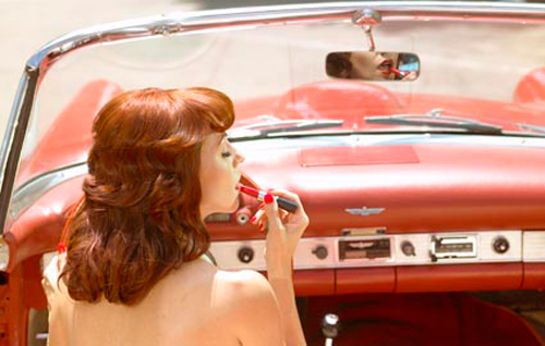 Mujer al volante pintándose los labios