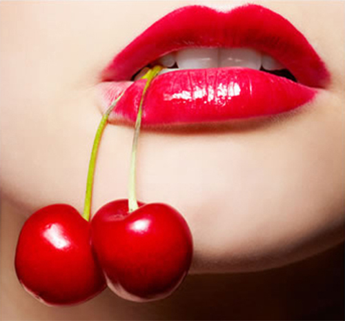 Labios con cerezas colgando