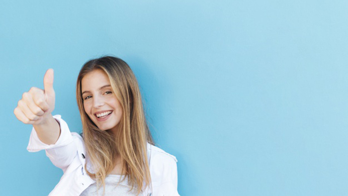 1mujer Joven1 Rubia Sonriente Que Muestra Pulgar Encima Muestra Contra Fondo Azul 23 2148178163 (1)