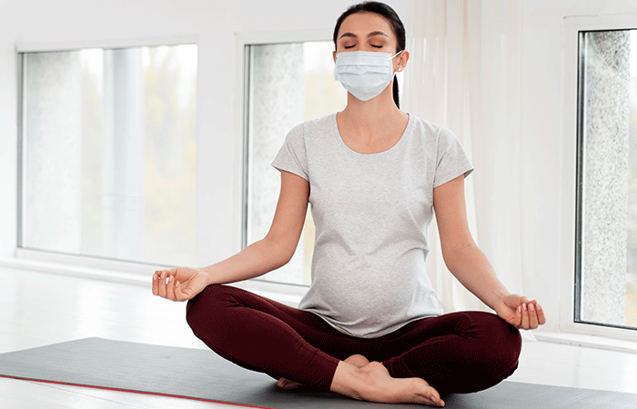 Pregnant Woman With Medical Mask Meditating (1)