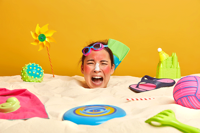 Young Woman Head With Sunscreen Cream On Face Surrounded By Beach Accessories (1)