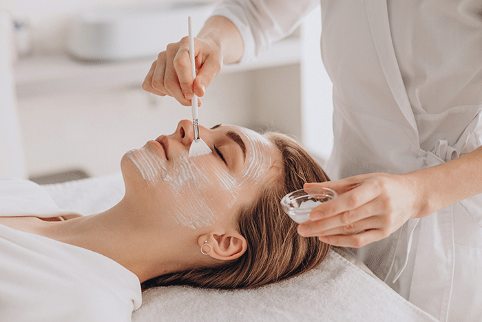 Cosmetologist Doing Face Treatment And Applying Face Mask